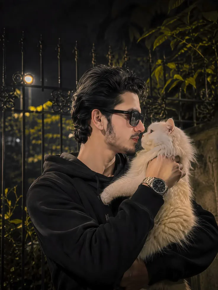 A side profile portrait of a handsome 20-year-old South Asian male model with thick, slicked-back black hair and light stubble.