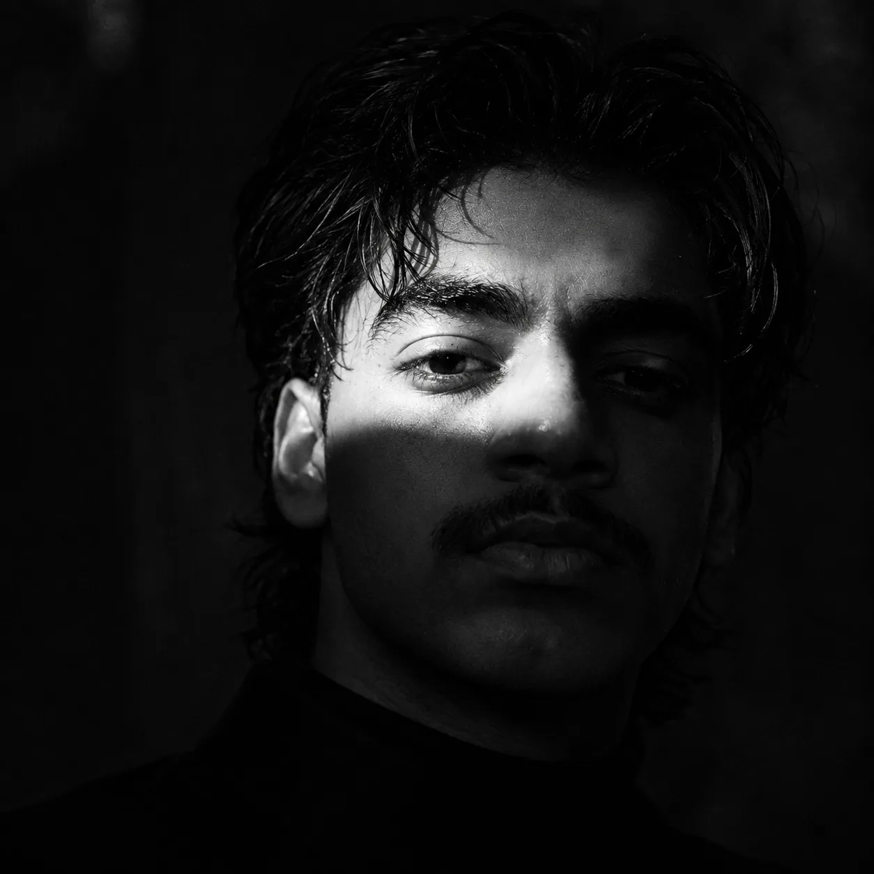 Create an ultra-realistic black-and-white cinematic portrait that closely recreates the provided reference image, preserving the same
