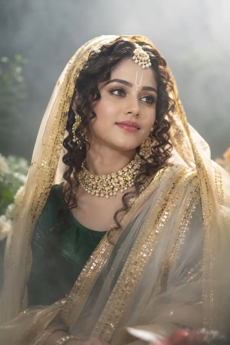 A beautiful Indian woman wearing an elegant deep green traditional blouse with a luxurious ivory-white and golden embroidered saree, the