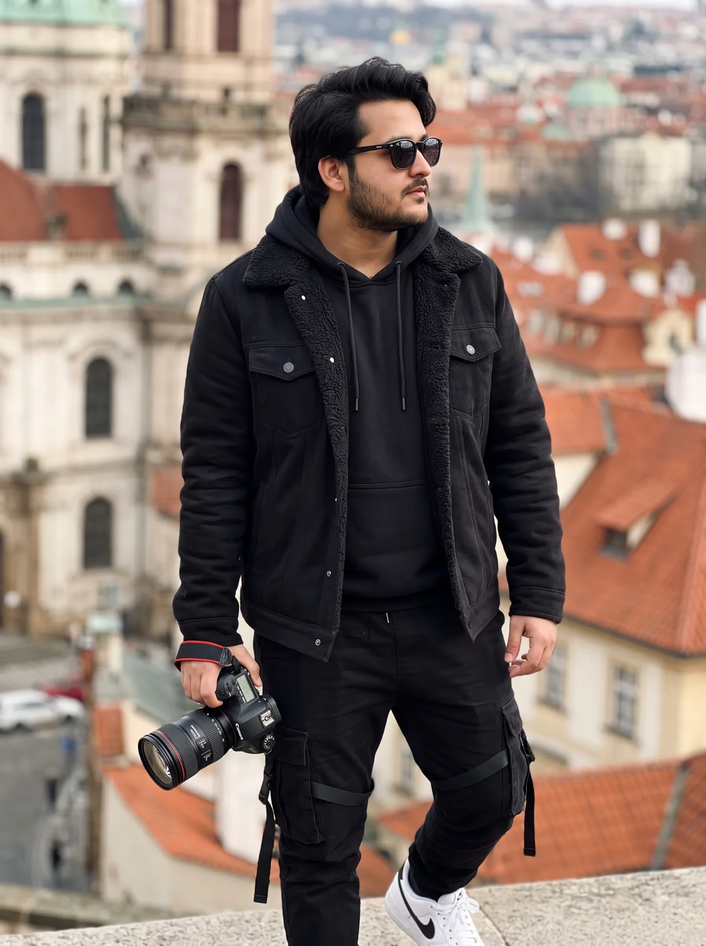 A young man stands outdoors.