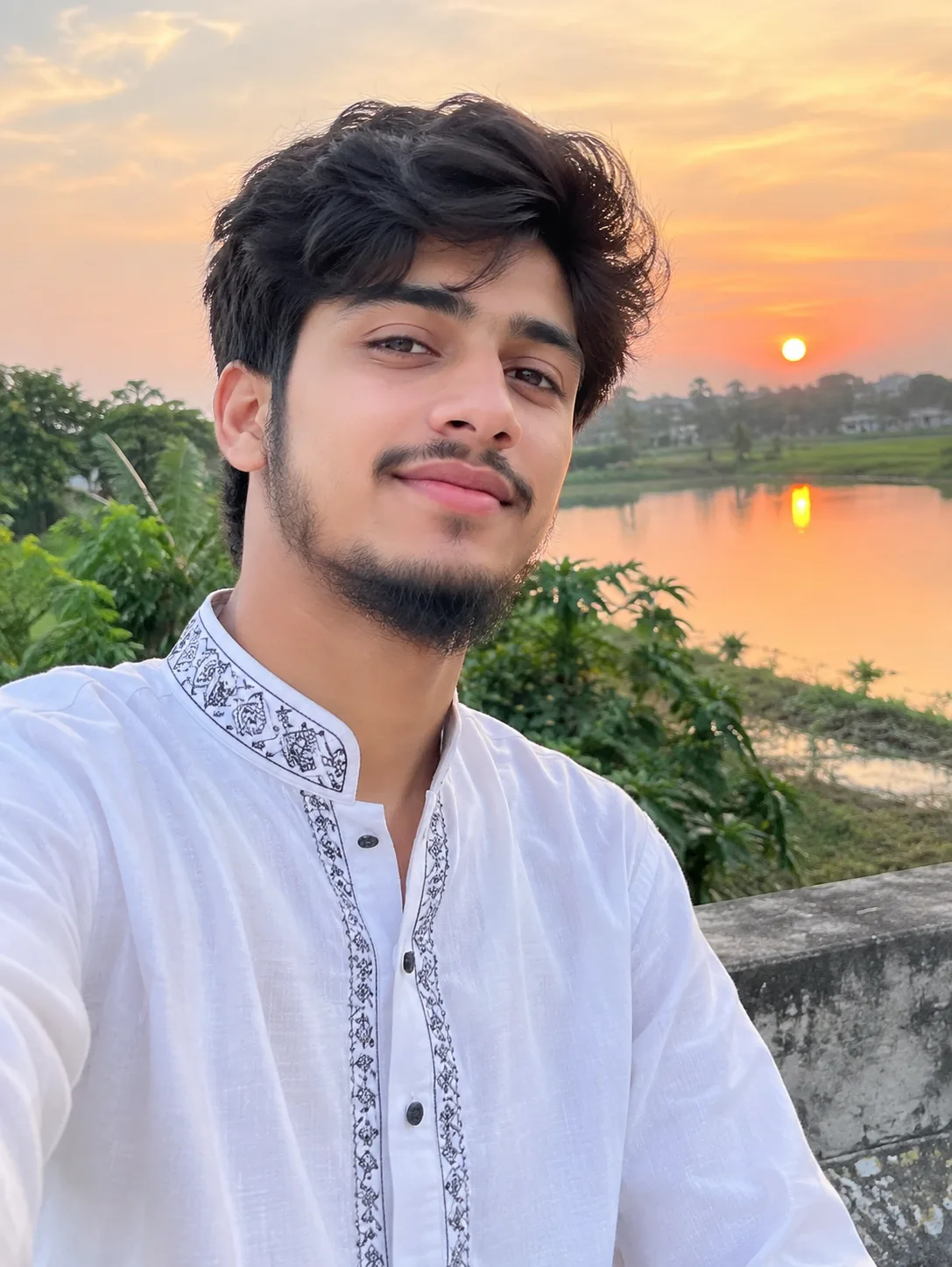 A highly realistic portrait of a handsome young man wearing an elegant white traditional kurta with subtle embroidery, standing beside a