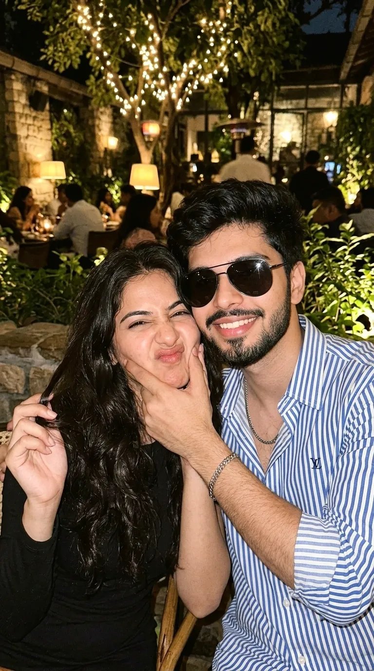 A close-up selfie of a young couple in a dimly lit, cozy, outdoor restaurant or patio.