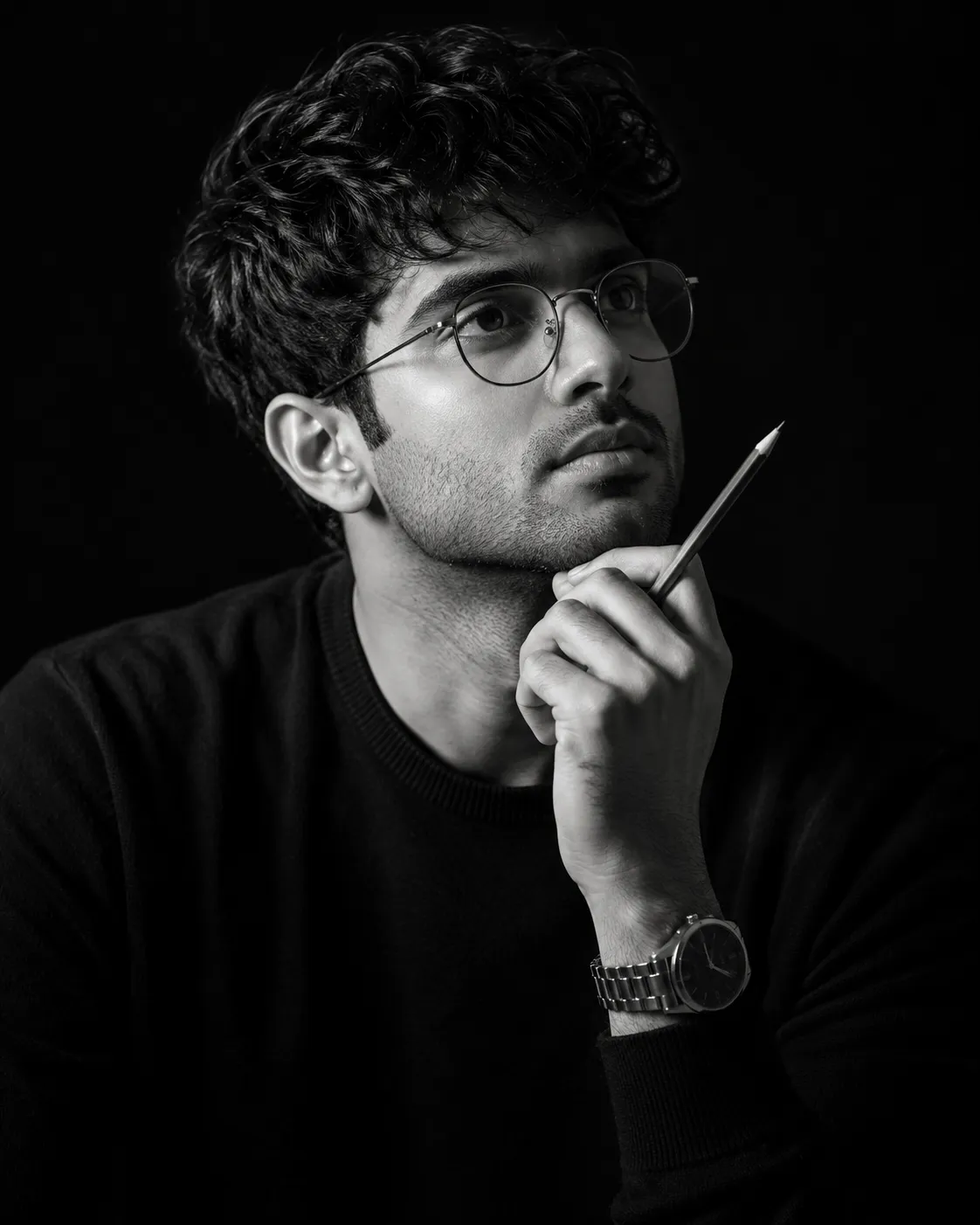 A dramatic black-and-white studio portrait of a thoughtful man with short, styled hair, captured using the uploaded reference image as the