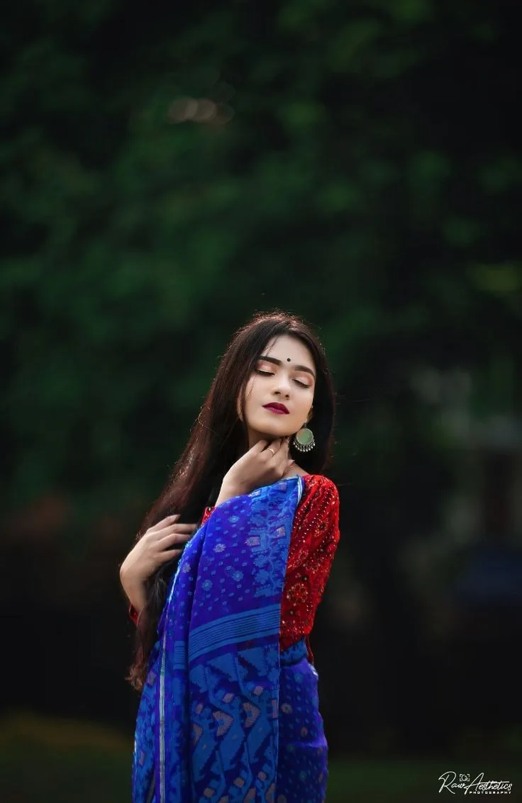 A photorealistic vertical medium shot of the young South Asian woman from the reference image, faithfully preserving her recognizable