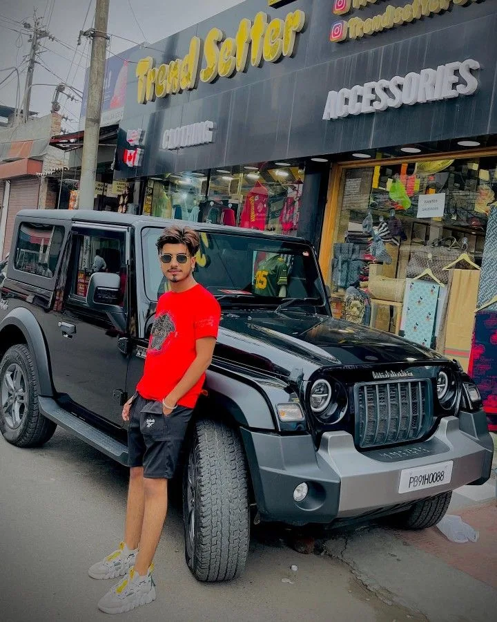 Candid Street Style Portrait of Young Man Leaning on Black SUV