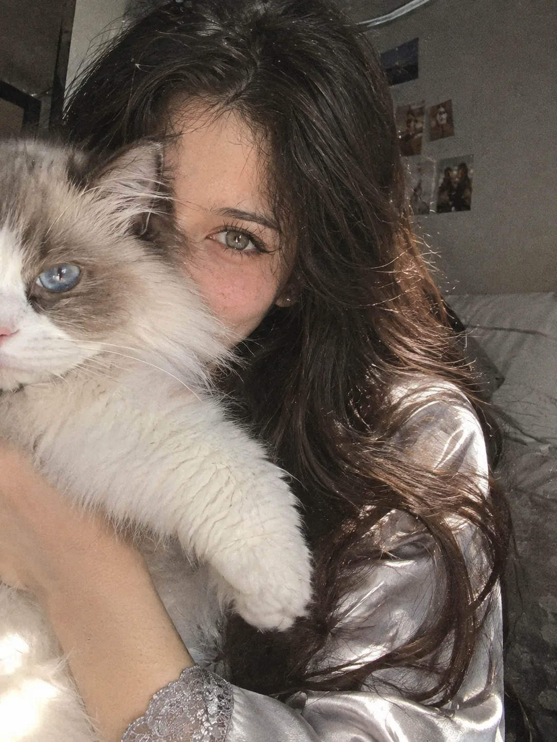 Create a raw selfie-style portrait of a young woman use uploaded photo as face and hair reference, with her ragdoll cat covering half her
