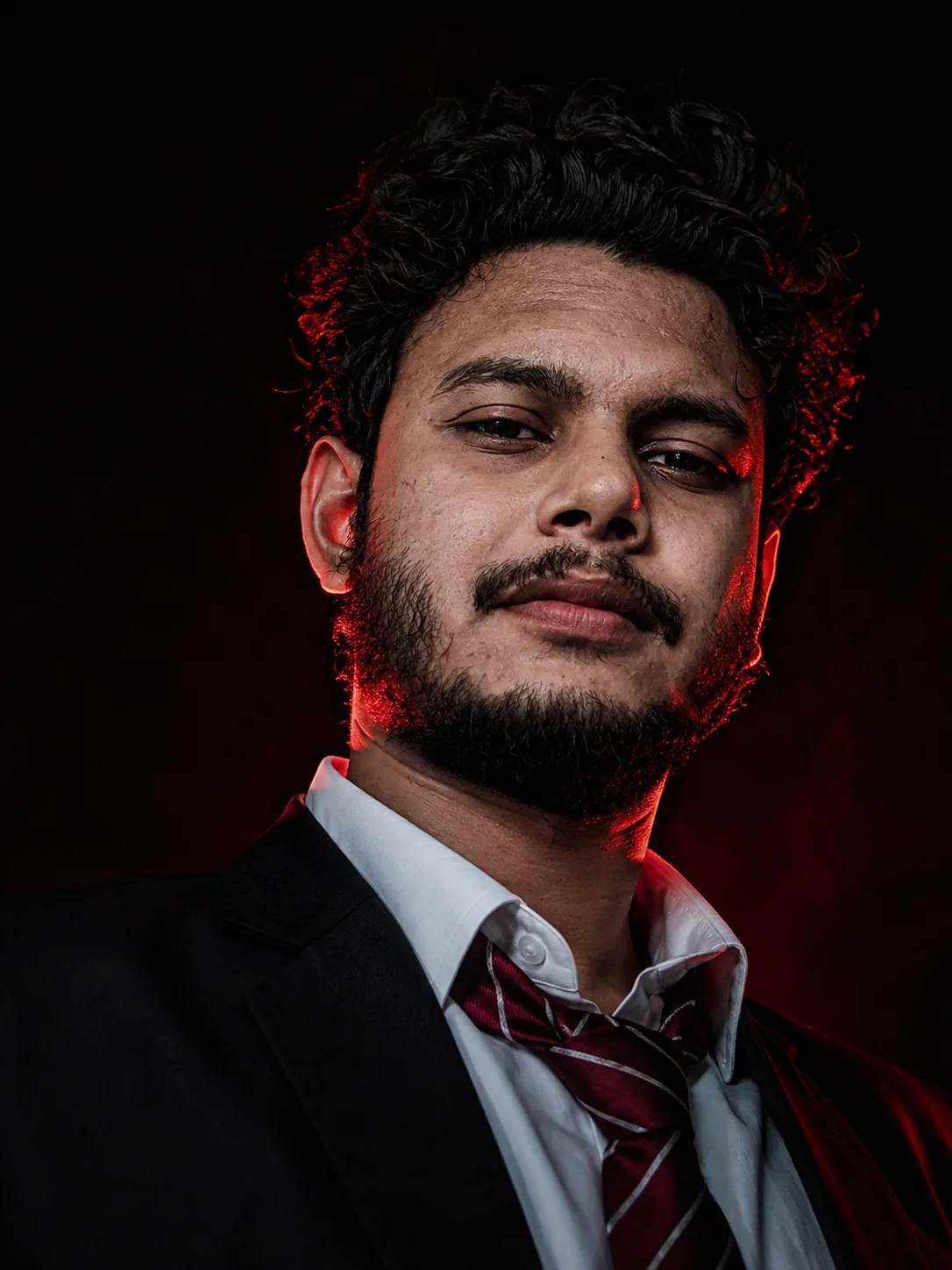 Cinematic low-angle close-up portrait of a handsome young East Asian man with messy, wavy dark hair.