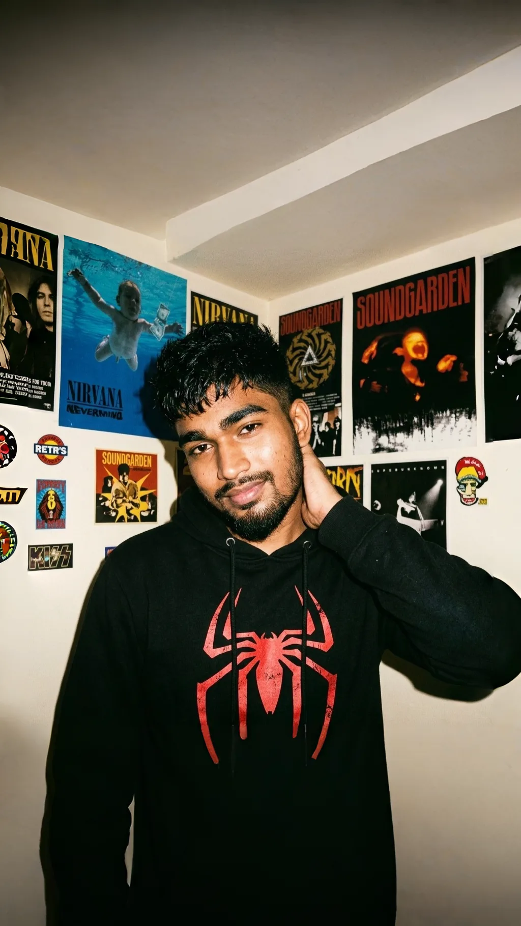 A photorealistic vertical medium shot of the young South Asian man from the reference image, faithfully preserving his exact recognizable