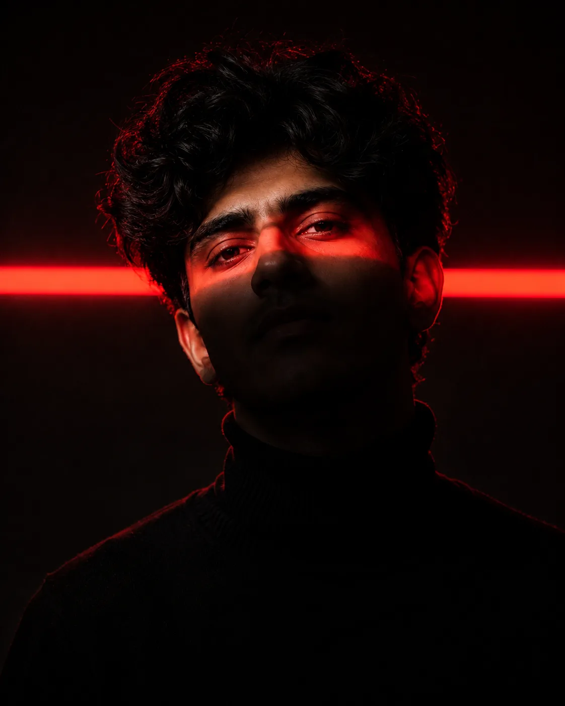 Cinematic studio portrait of a young man with messy textured hair, wearing a black turtleneck, centered composition, dark minimal
