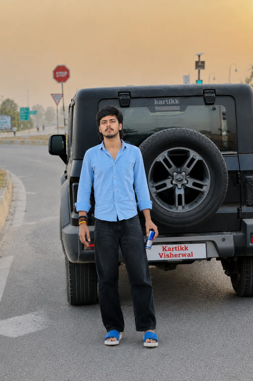 Ultra-realistic cinematic full-body portrait of a young Indian man standing confidently in front of a rugged black off-road SUV on a wide