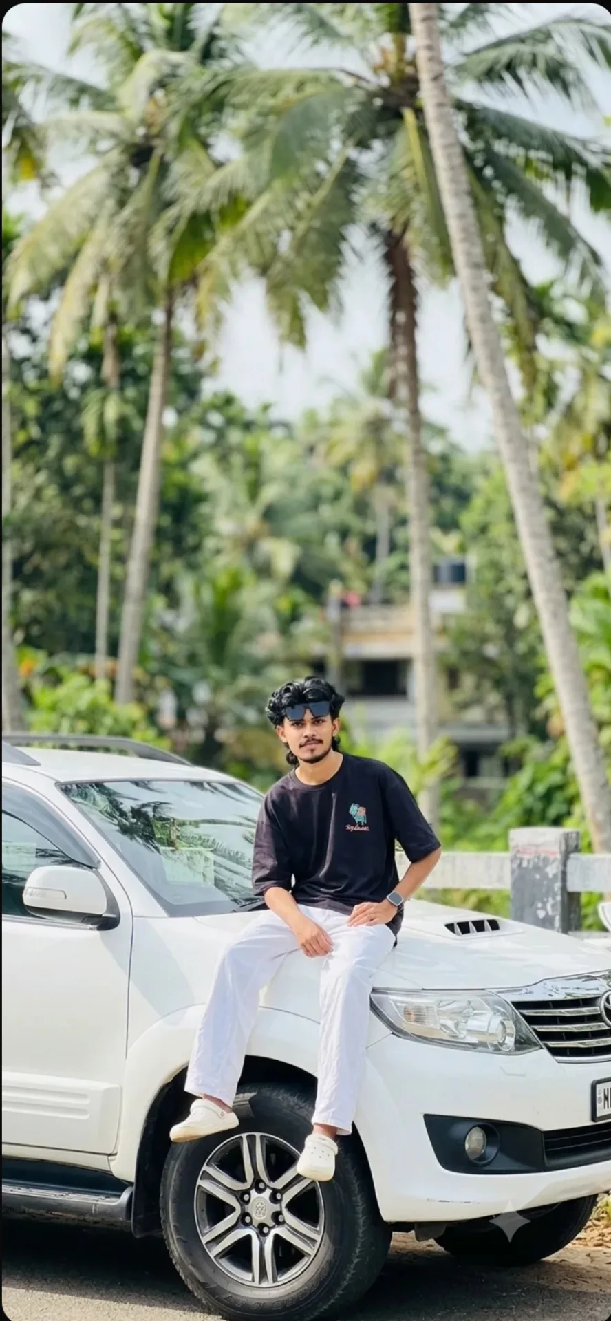 Candid Outdoor Streetwear Portrait of Young Man Sitting on White SUV Hood
