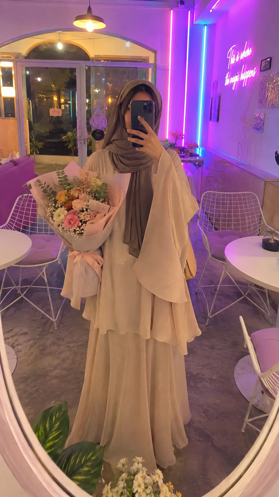 convert the uploaded image into A full-body mirror selfie of a modest fashion woman standing inside a cozy aesthetic café with neon purple