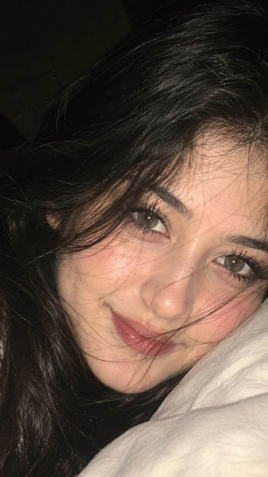Absolutely. The image is essentially a very close-up, intimate smartphone/flash portrait, with the face lying sideways and loose hair