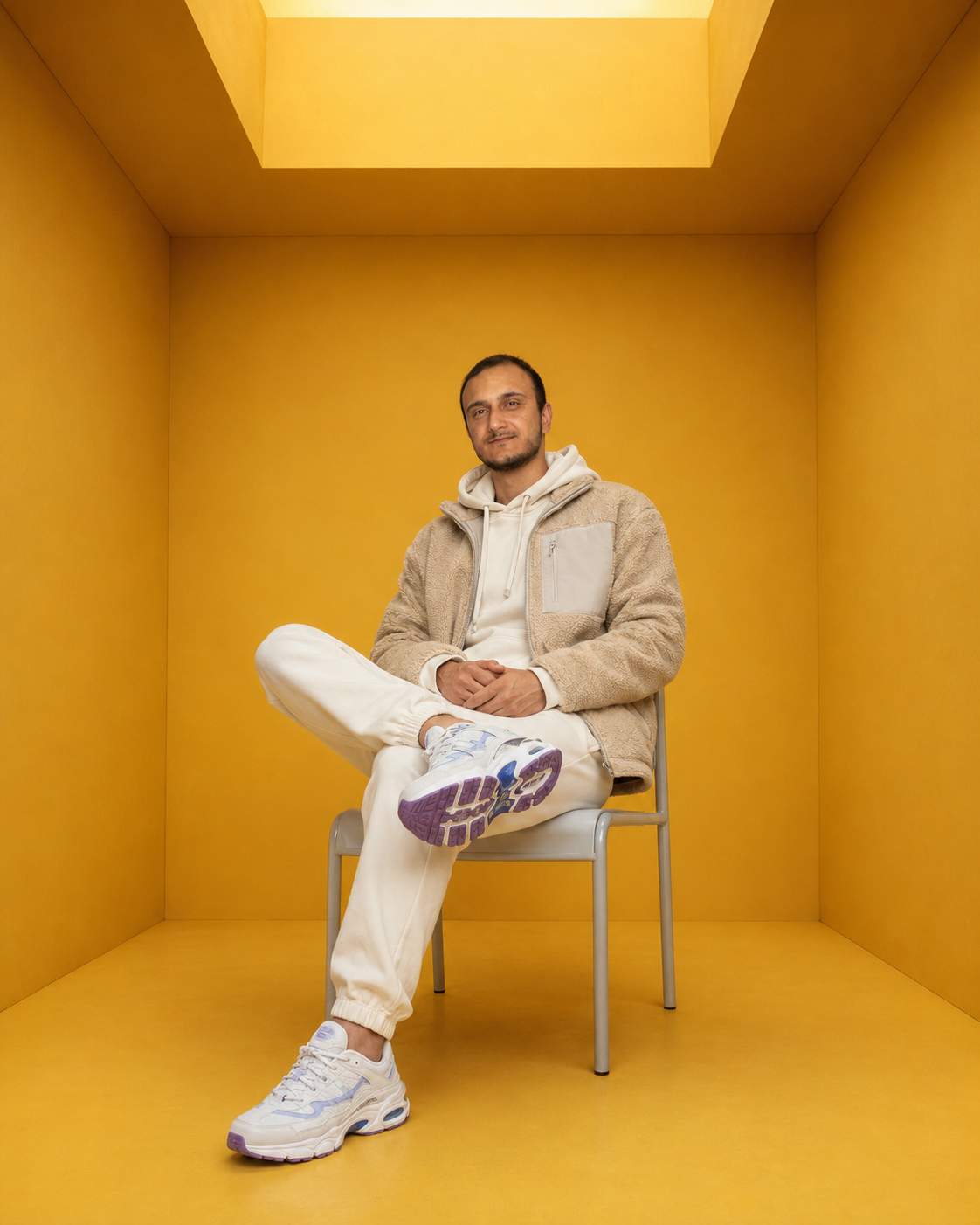 Create an ultra-high-resolution, photorealistic full-body fashion portrait of a handsome man seated inside a perfectly symmetrical