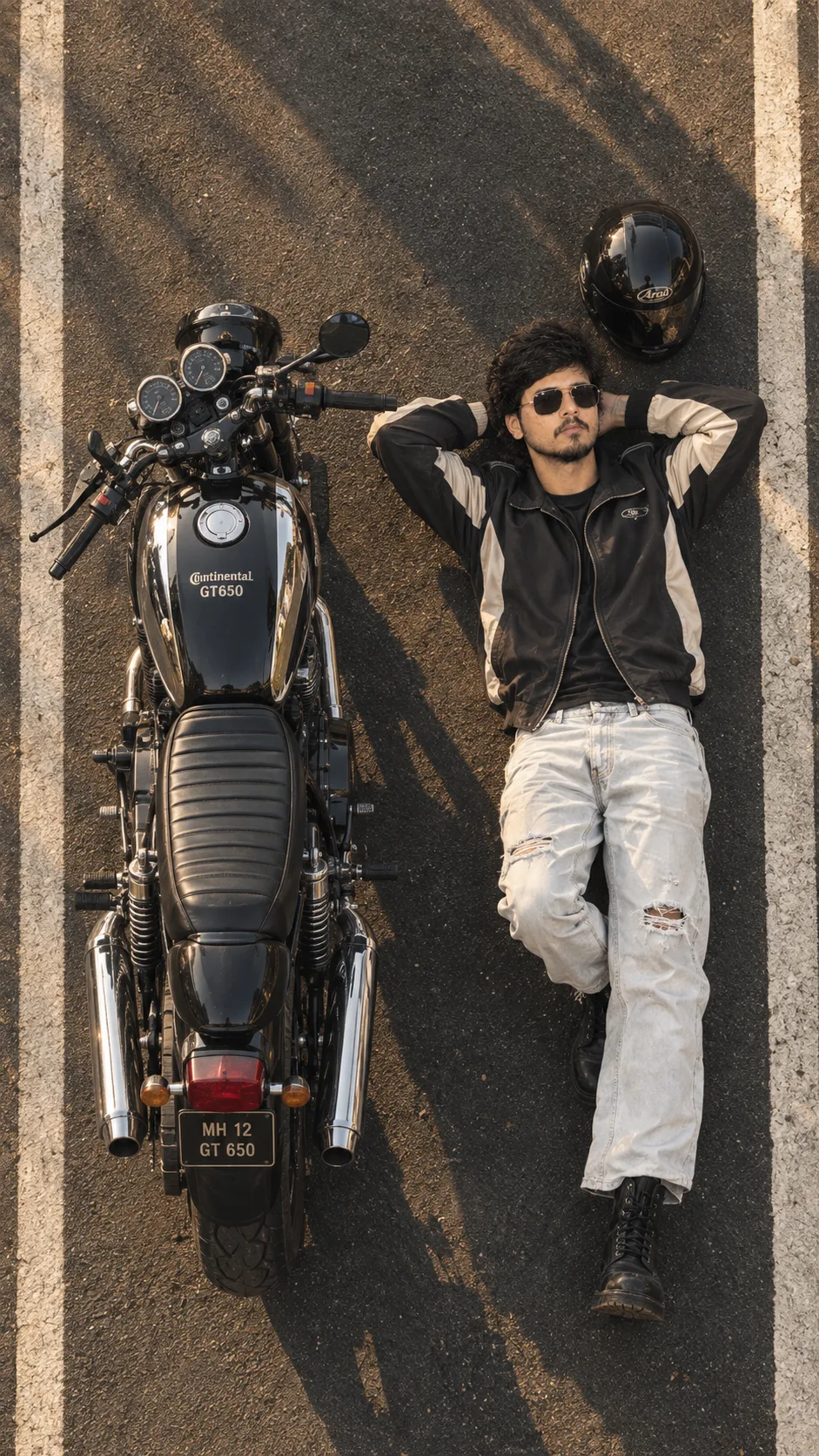 A slim-fit young man. Ultra-realistic cinematic top-down drone photograph of a stylish young man lying on a dark asphalt parking lot beside