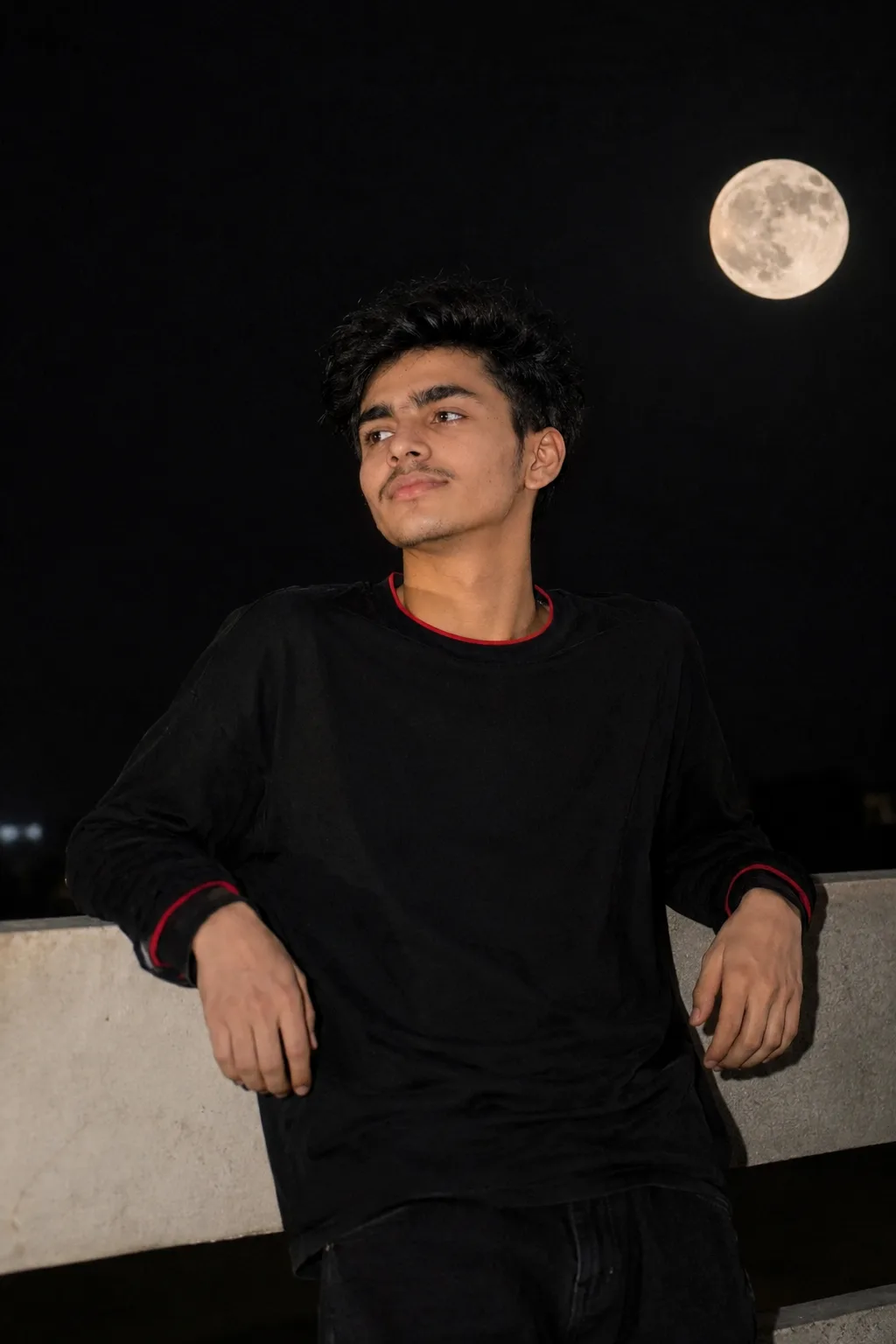 “Generate a realistic portrait of a young man standing and leaning his back and both elbow on railing at top floor, behind him clean dark