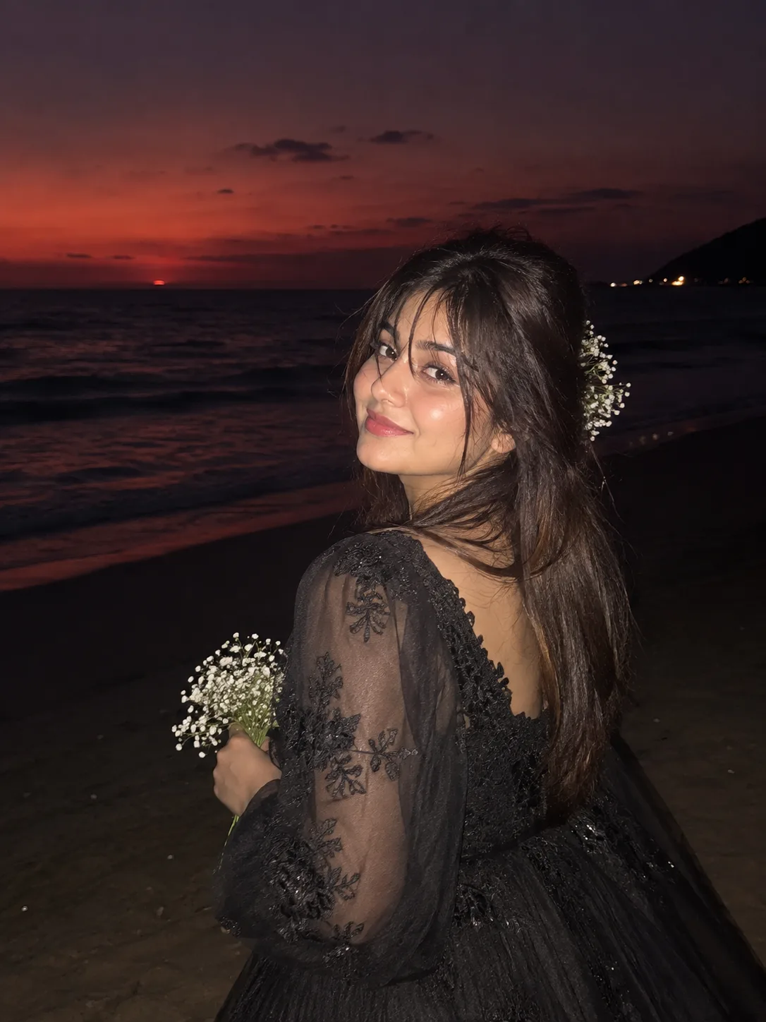 Convert the uploaded image into Make me look like i am on a beach where its dark but someone took my picture from a flash and face is a