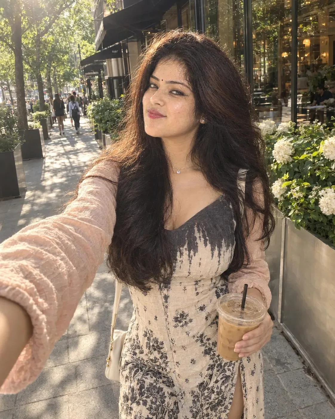 Photorealistic lifestyle selfie of a young woman walking on a sunny European café-lined street.