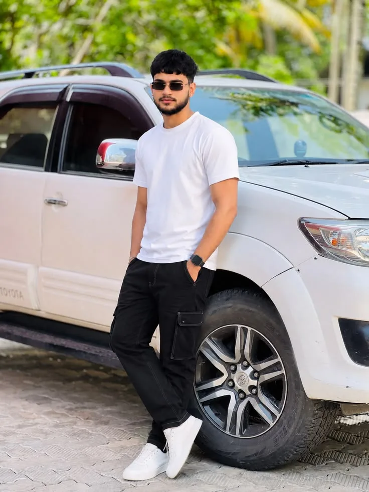 A photorealistic vertical full-length shot of the young South Asian man from the reference image, faithfully preserving his recognizable