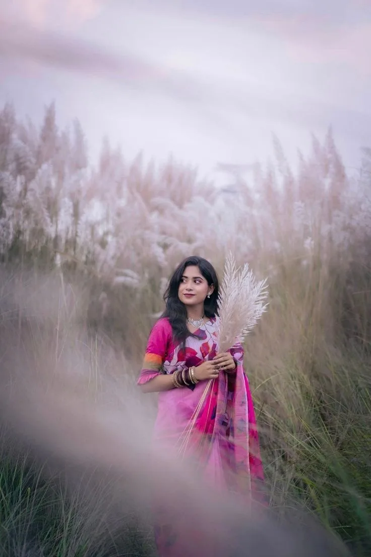 A photorealistic vertical medium shot of the young South Asian woman from the reference image, faithfully preserving her recognizable