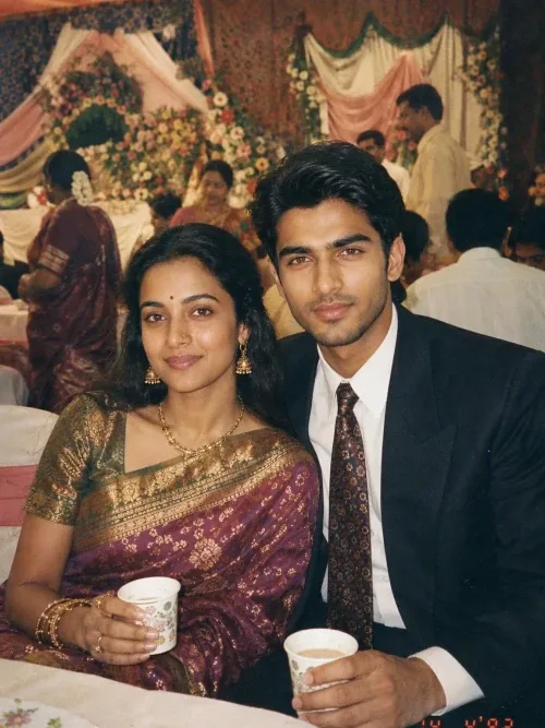 A warm 1990s Indian wedding reception snapshot featuring a young couple sitting closely together at a decorated banquet hall.