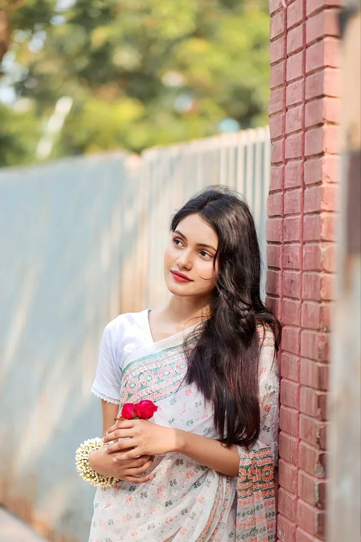 A photorealistic vertical medium portrait of the young South Asian woman from the reference image, faithfully preserving her exact facial