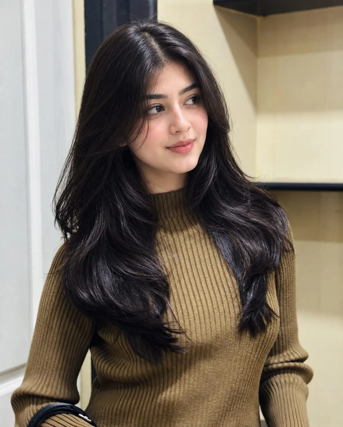 A highly realistic indoor portrait of a young South Asian woman with long, thick, glossy black hair, soft natural makeup, clear smooth