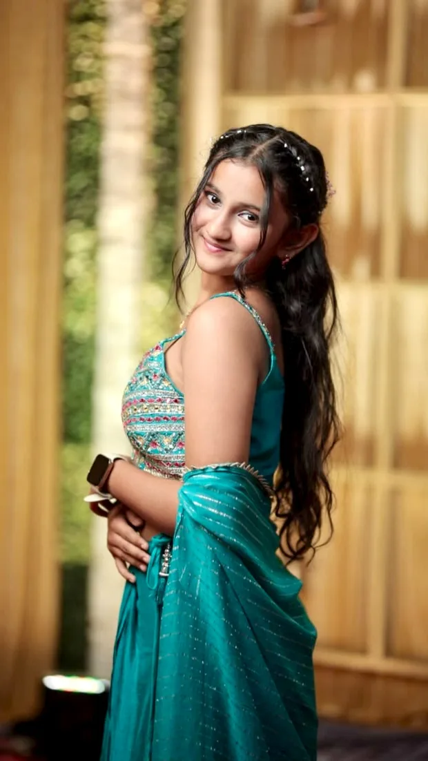 A photorealistic vertical medium portrait of the young South Asian woman from the reference image, faithfully preserving her exact