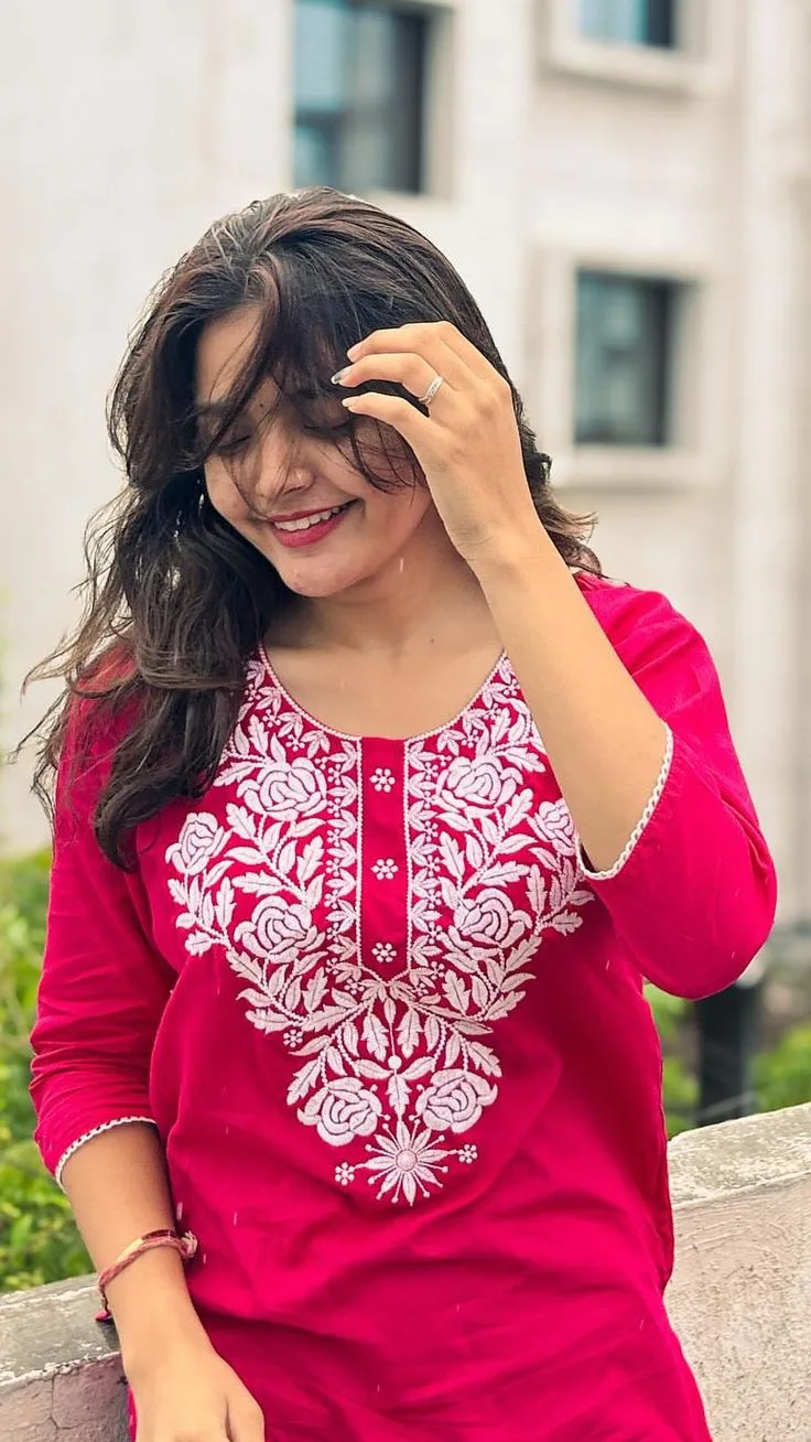 A photorealistic vertical medium shot of the young South Asian woman from the reference image, faithfully preserving her recognizable