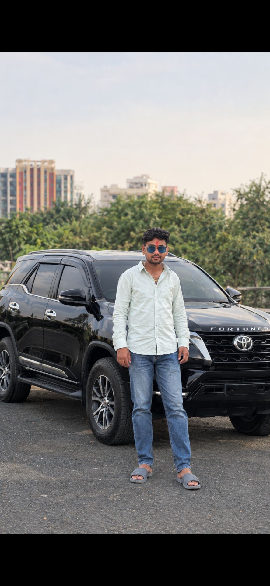 Create an ultra-photorealistic 4K UHD full-body portrait photograph of a stylish young South Asian man standing confidently in front of a