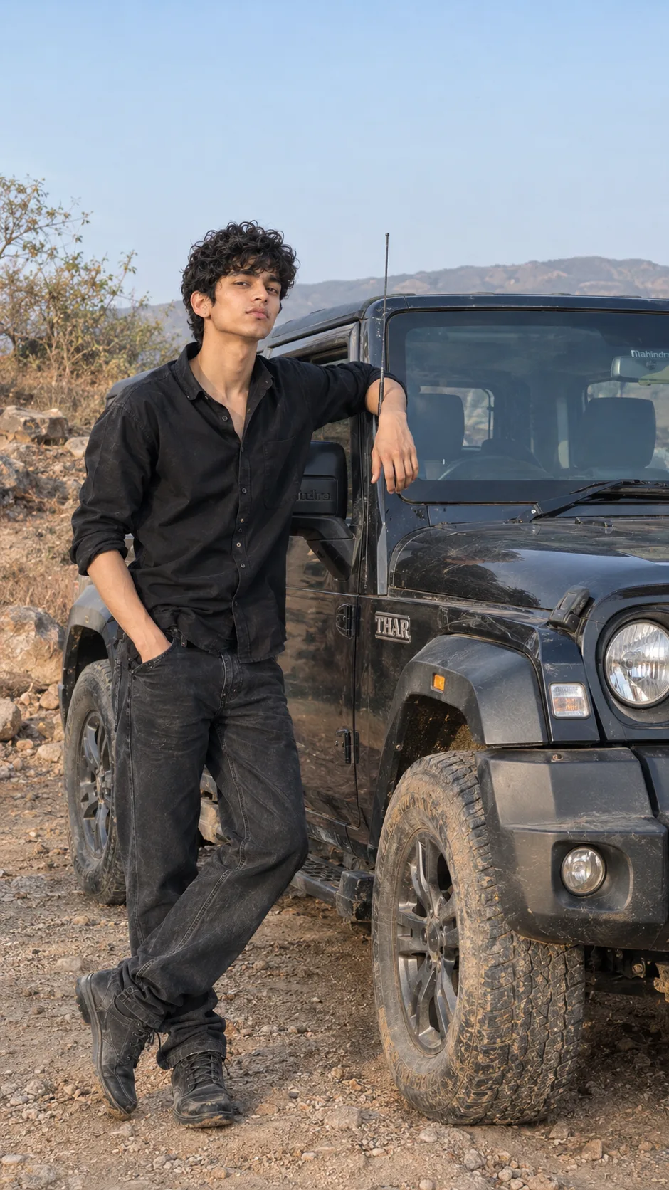 Ultra realistic full body photograph of a young man standing next to a Mahindra Thar during daytime, shot on a real DSLR camera.