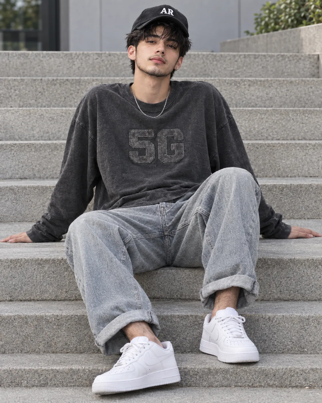 Create a highly photorealistic, full-body portrait of a handsome young South Asian man (early 20s) sitting casually on concrete outdoor