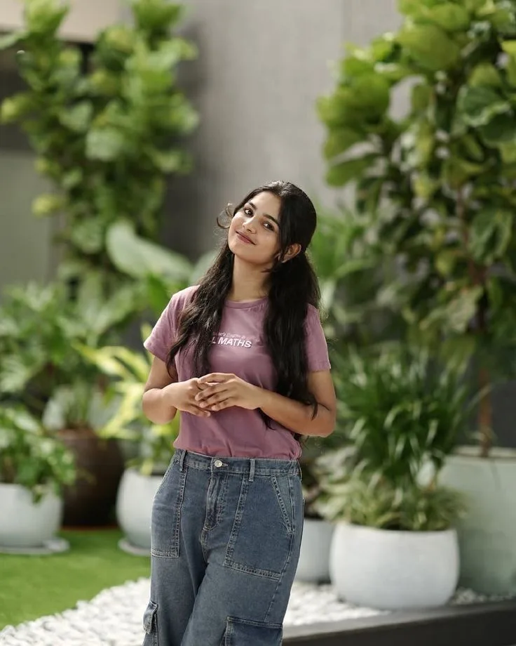 A photorealistic vertical medium-full portrait of the young South Asian woman from the reference images, faithfully preserving her exact