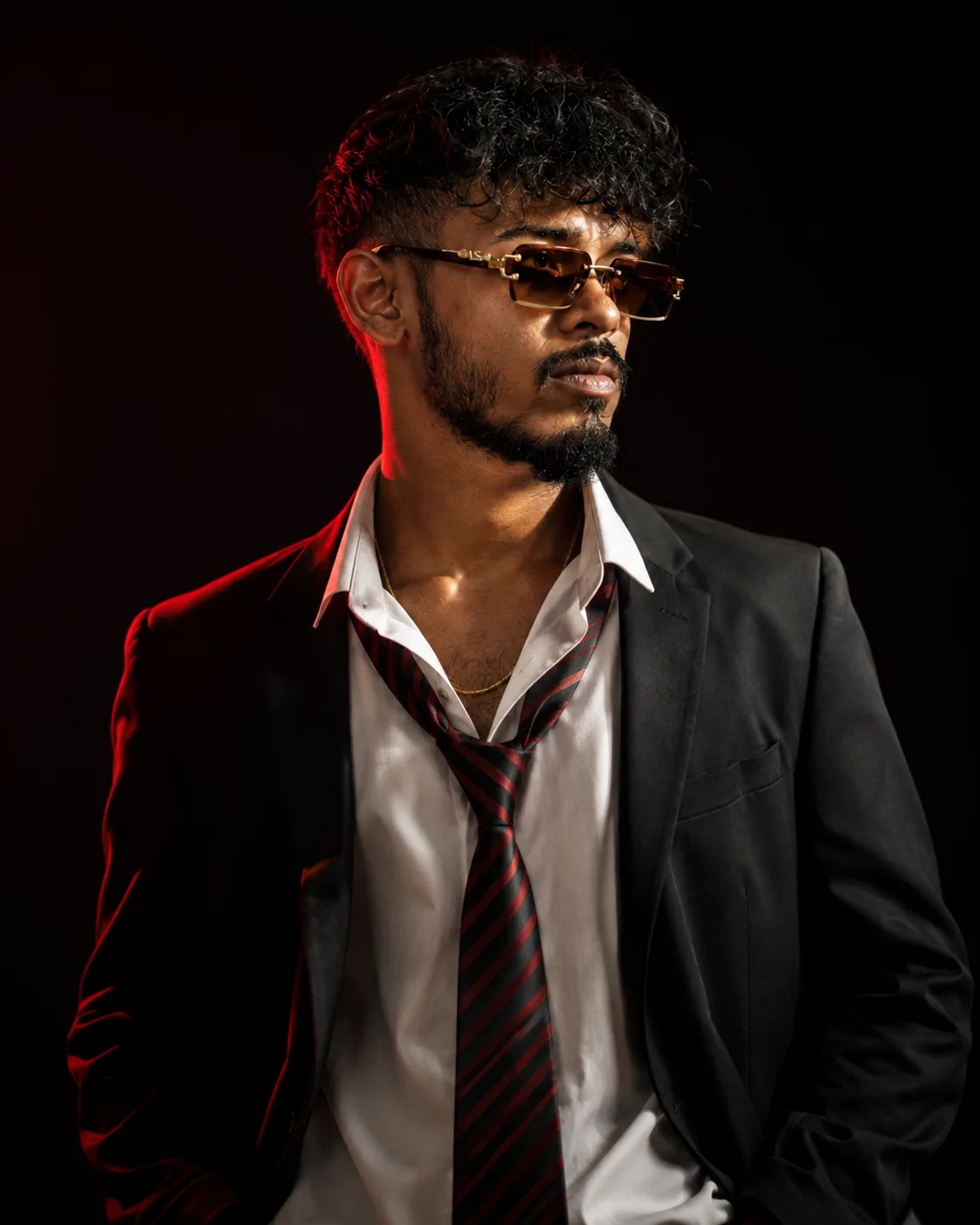 Create an ultra-realistic cinematic fashion portrait of a confident young adult man in a dark luxury editorial style.