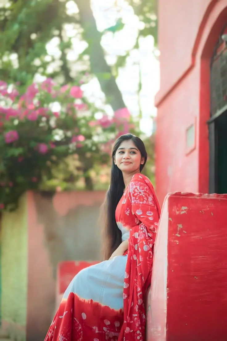 A photorealistic vertical medium shot of the young South Asian woman from the reference image, preserving her facial identity, soft