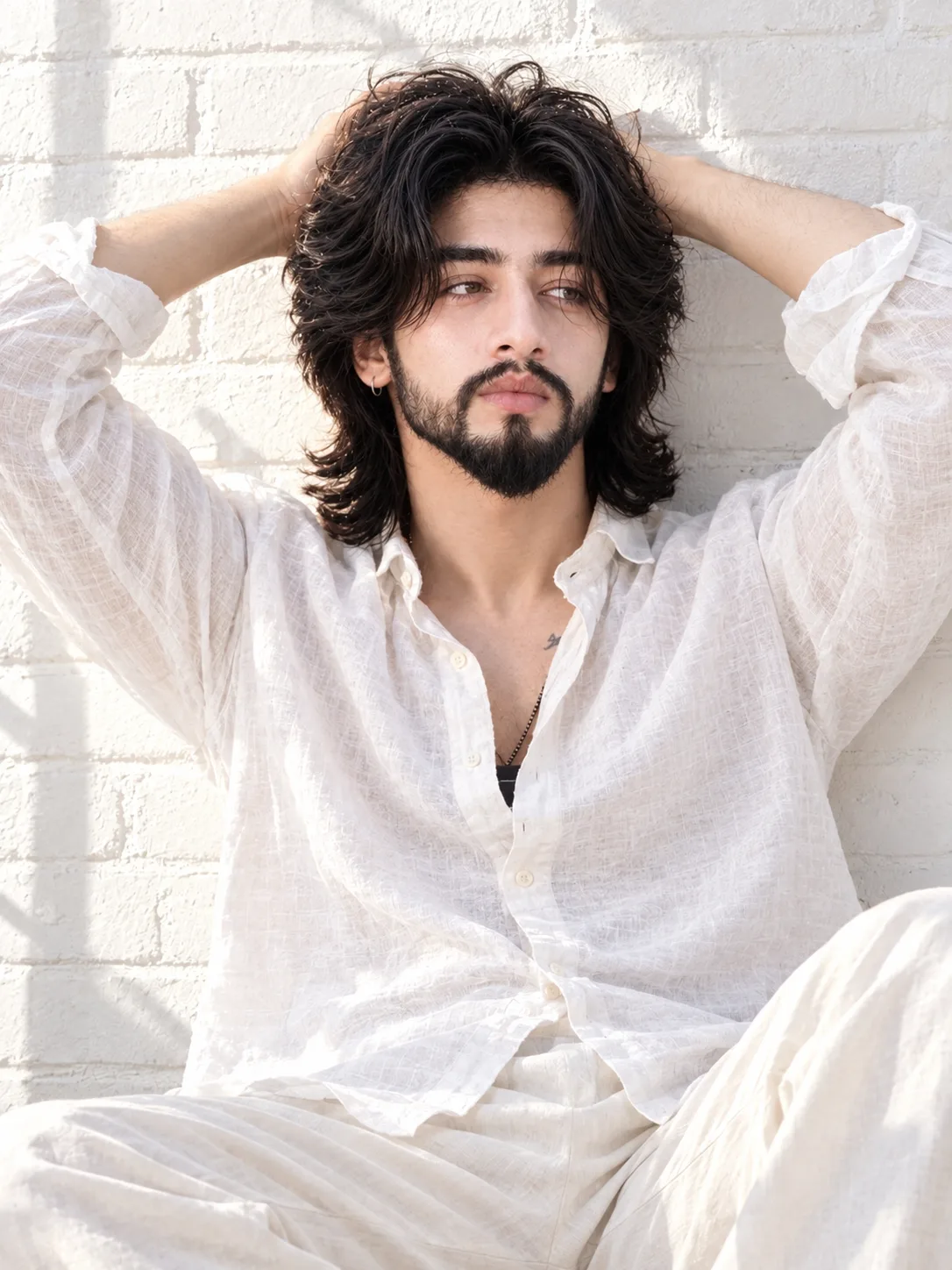 A high-definition photograph from a direct, straight-on medium perspective shows a man in a relaxed, sunlit pose.