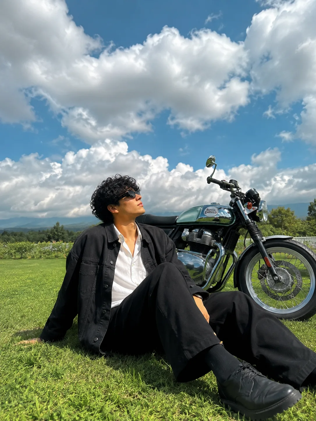 A highly realistic 8K HD high-resolution photo (3:4 aspect ratio) of a young man sitting casually on a green grassy field illuminated by