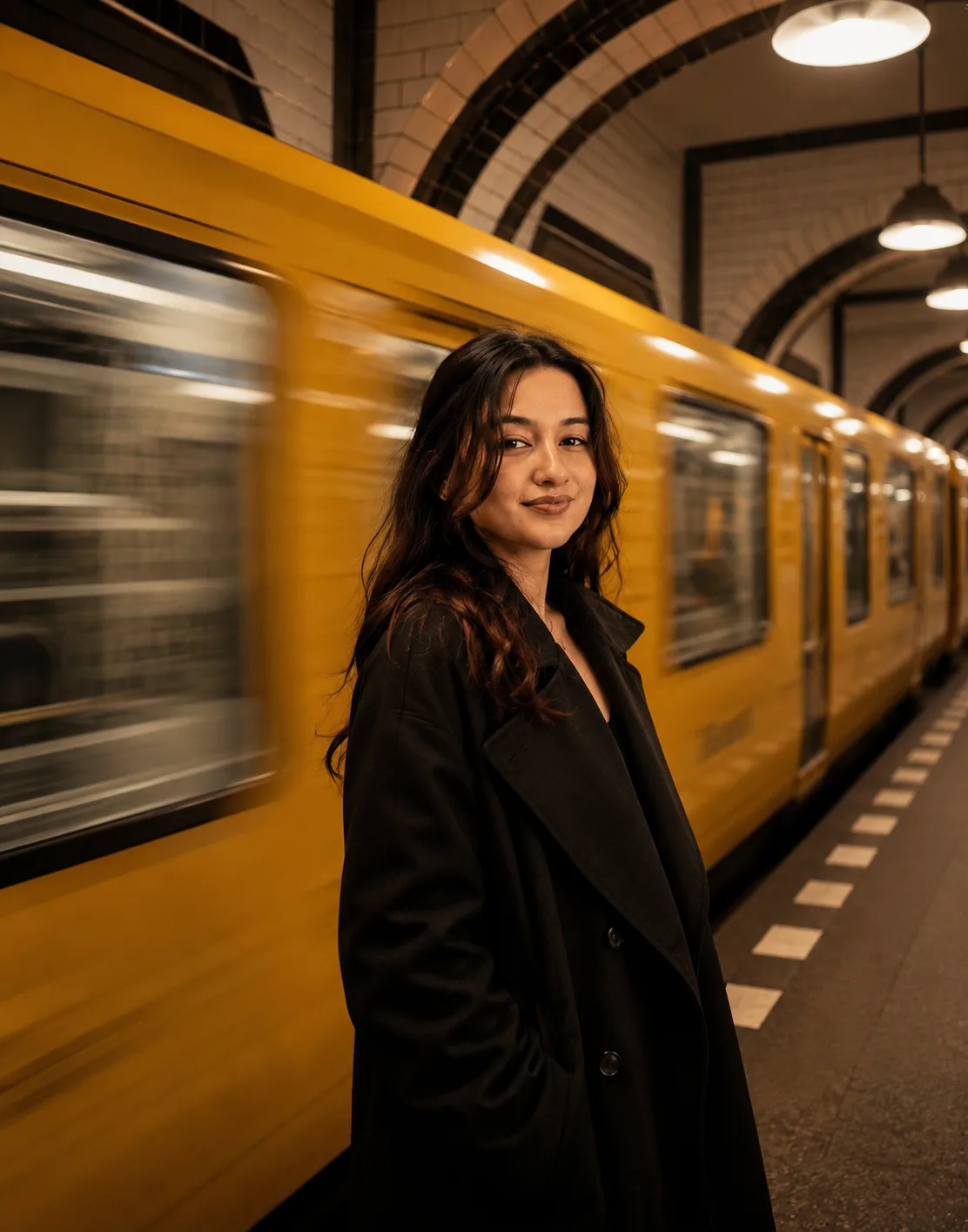 frola (Hommedium shot captures a yount FODAS On Maman-wittienert-wind-swept black hair standing on d subway platform as a yellow train