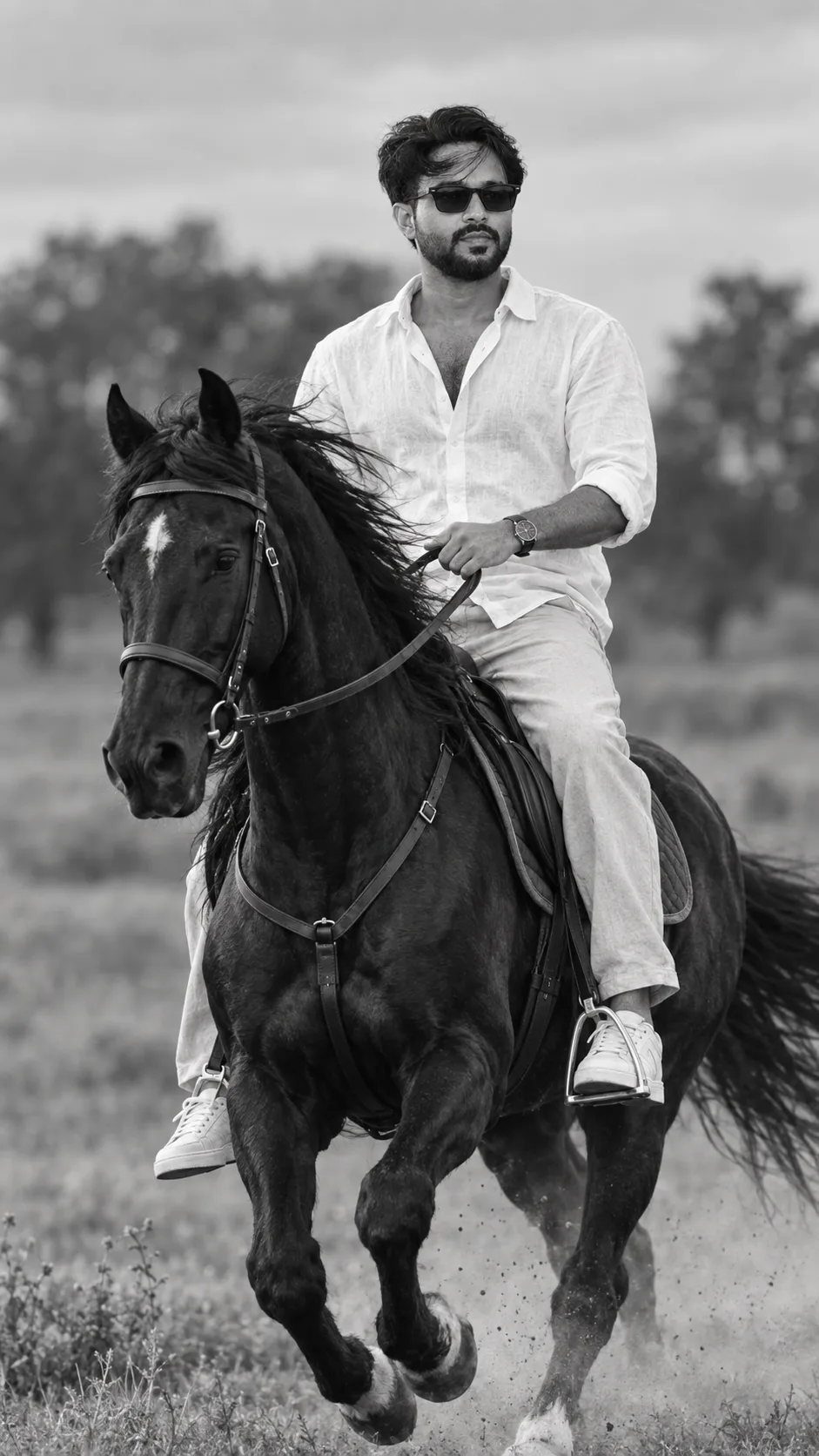 Create a highly realistic cinematic black-and-white full-body portrait of a stylish young Indian man riding a powerful black horse in an