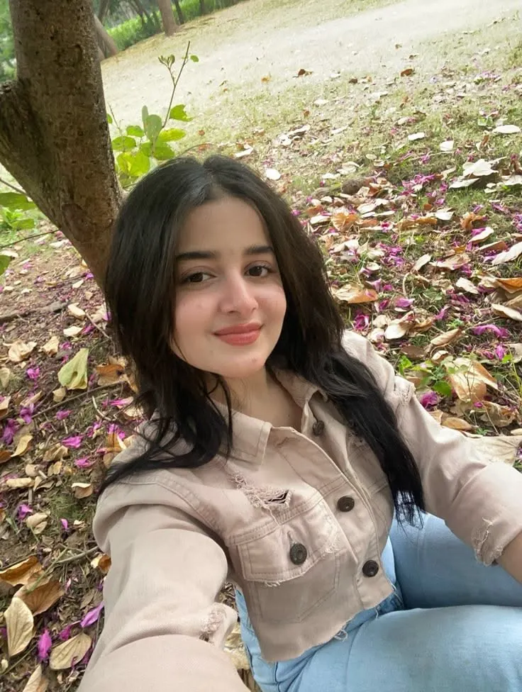 A high-quality, candid 3:4 aspect ratio selfie-angle portrait of a young South Asian woman with long, straight black hair parted in the