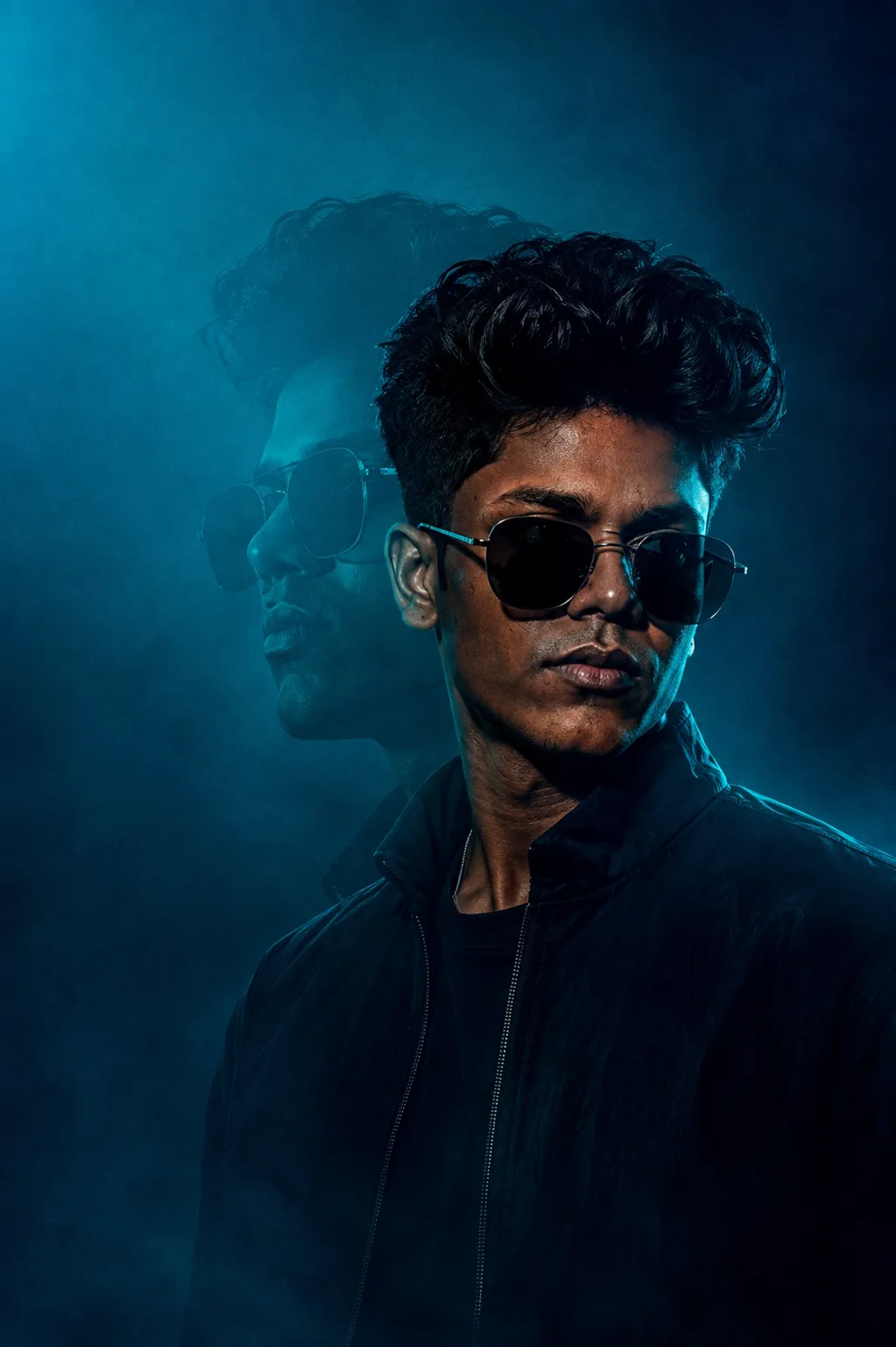 moody cinematic portrait of a man in dark jacket, front facing but slightly turned, minimal expression, dark teal and cyan studio lighting,