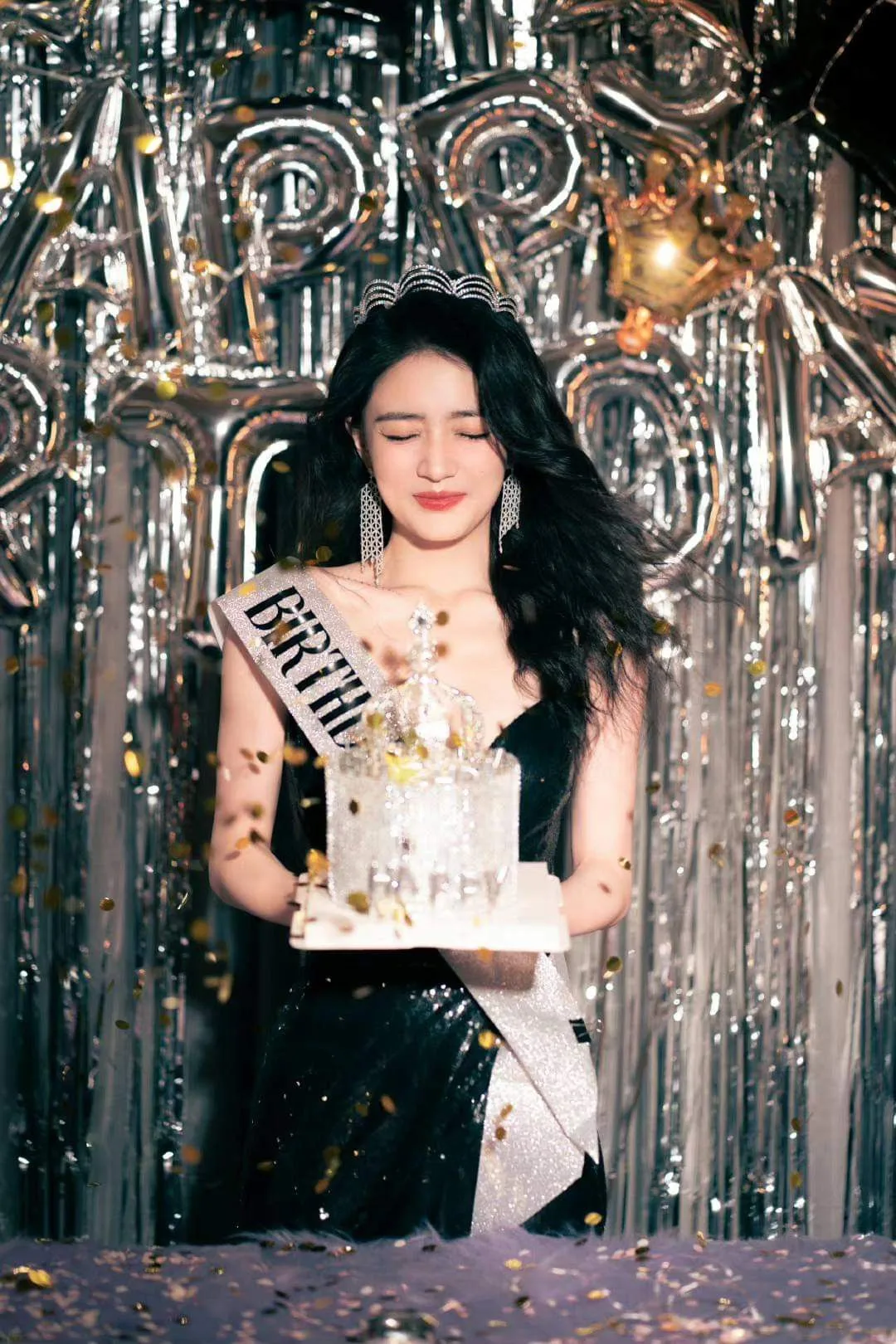 Create an ultra-realistic cinematic vertical birthday portrait of a young woman standing elegantly at a glamorous birthday celebration.
