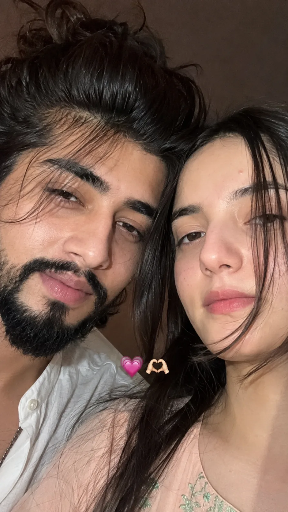An extreme, high-definition close-up selfie shows a young couple with their heads close together, looking into the camera.