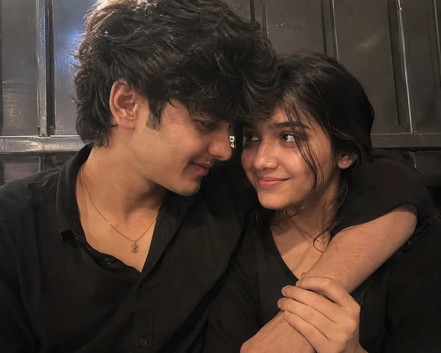 Create an ultra-photorealistic, heartwarming close-up candid photograph of two young Indian adults, a man and woman, sitting very close
