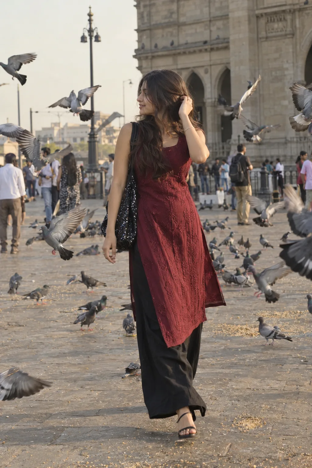 78 A realistic, full-body candid shot of a stylish South Asian woman walking gracefully through a public plaza filled with pigeons flying
