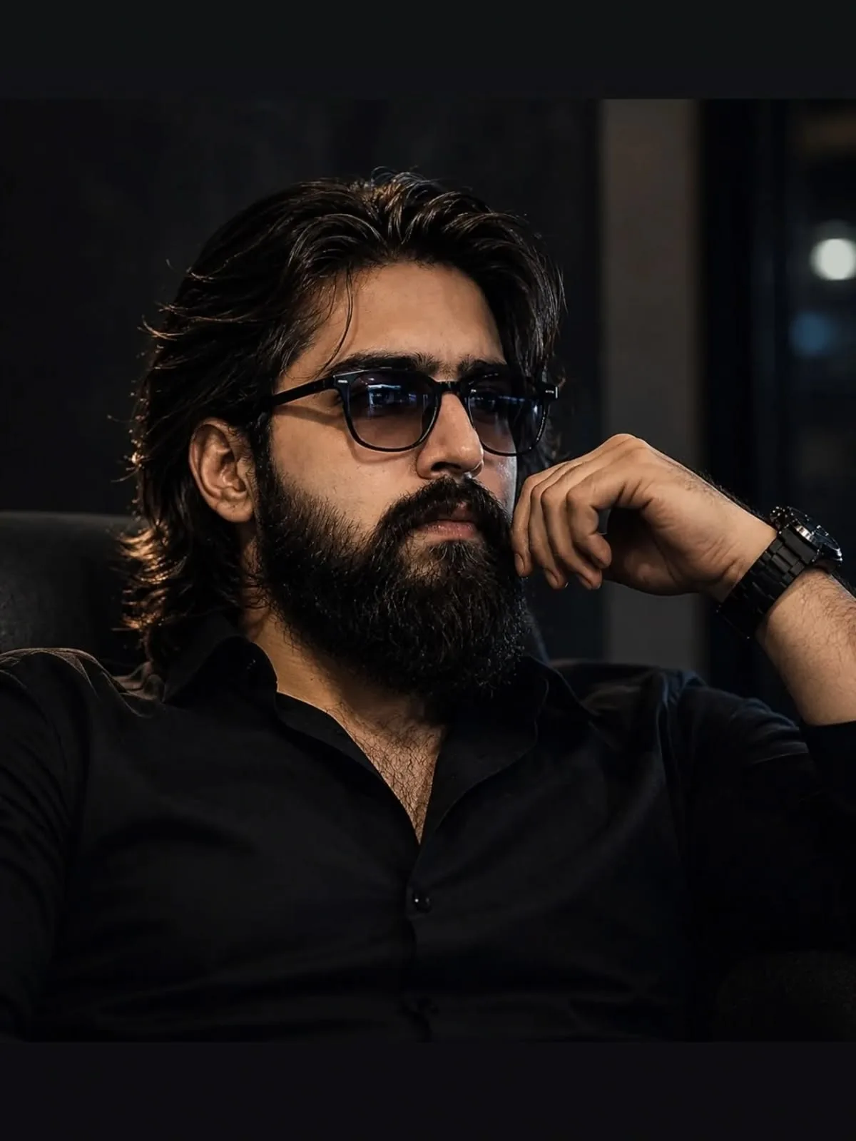 Close-up cinematic portrait of a powerful and handsome 30-year-old South Asian man with long, flowing wavy black hair and a thick,