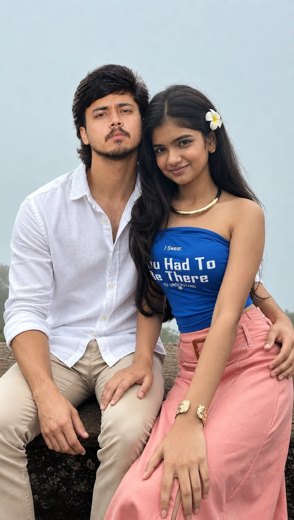 Create an ultra-realistic vertical DSLR photograph of a young South Asian couple sitting closely together on a rugged stone ledge outdoors.