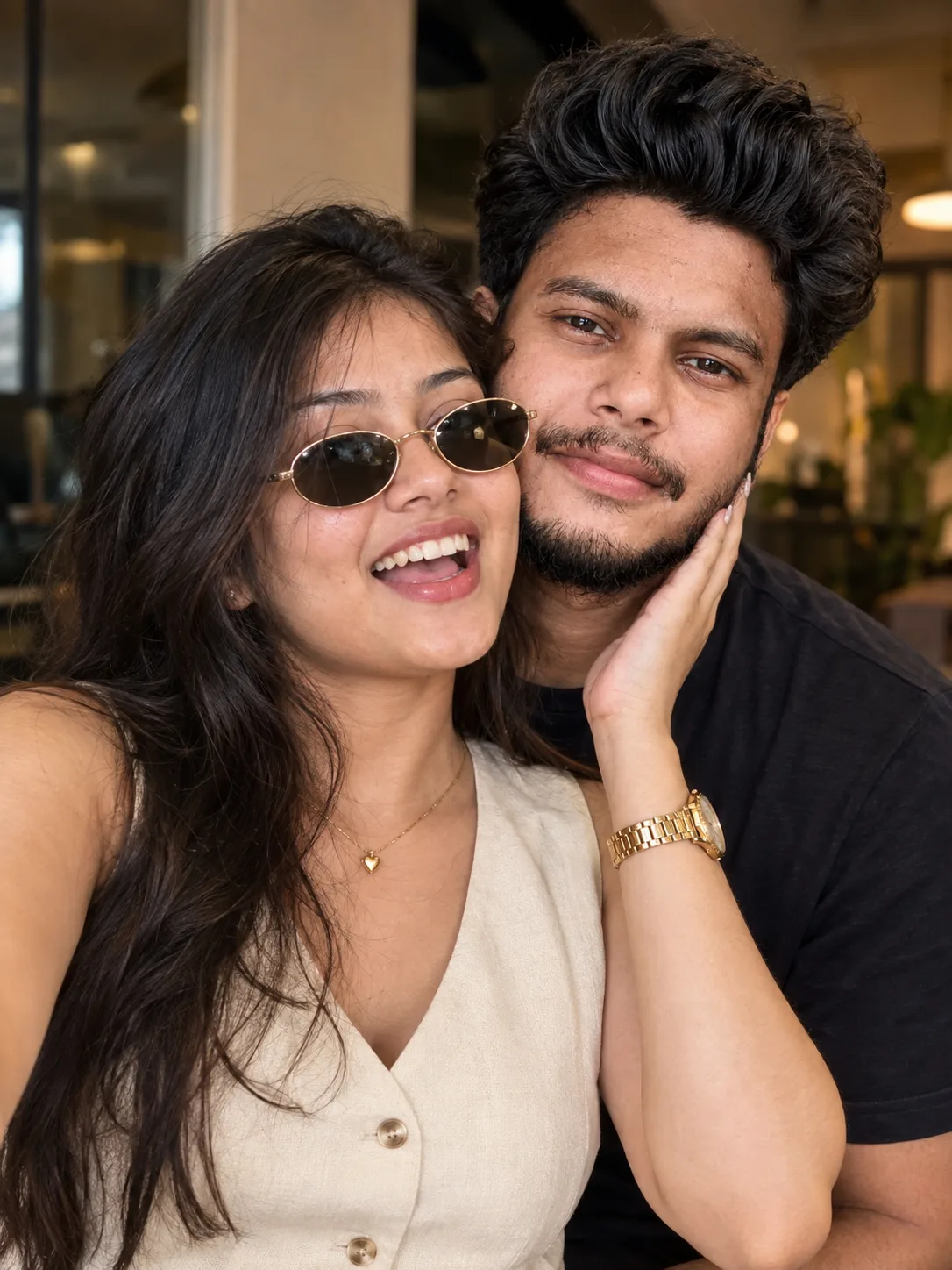 **Prompt:** Close-up portrait of a young South Asian couple posing affectionately indoors.