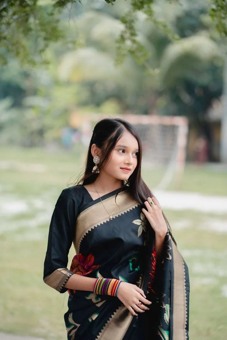 A photorealistic vertical medium shot of the young South Asian woman from the reference image, faithfully preserving her recognizable