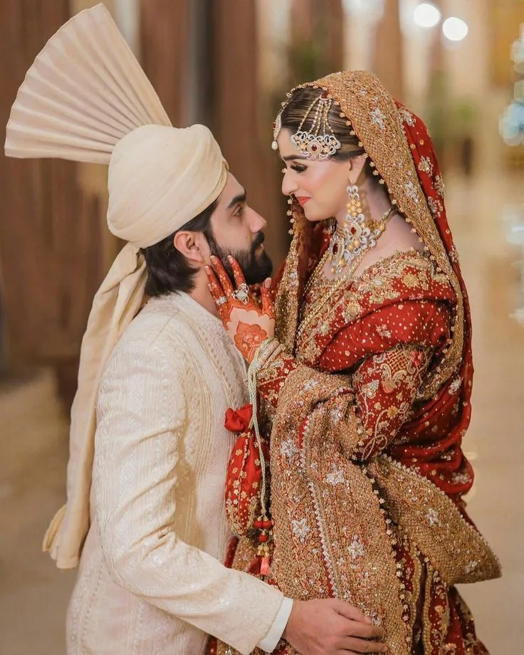 iA young man and woman in traditional Pakistani wedding attire, a bride and groom, are looking at each other intimately.